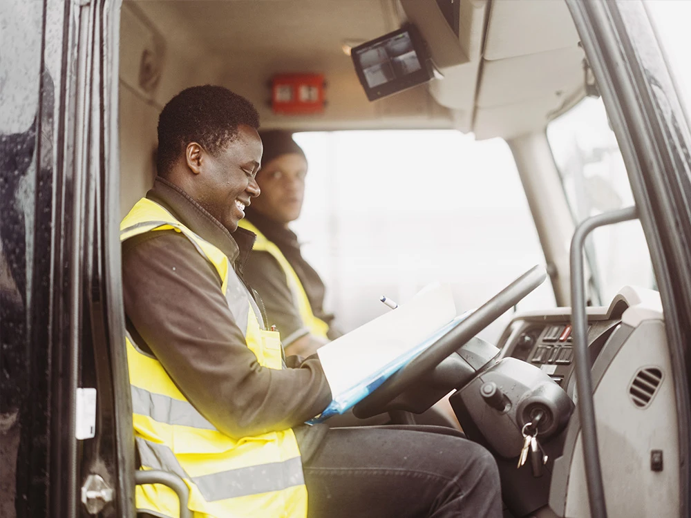 HGV Driver in the cab of the vehicle marking down his deliveries on paper