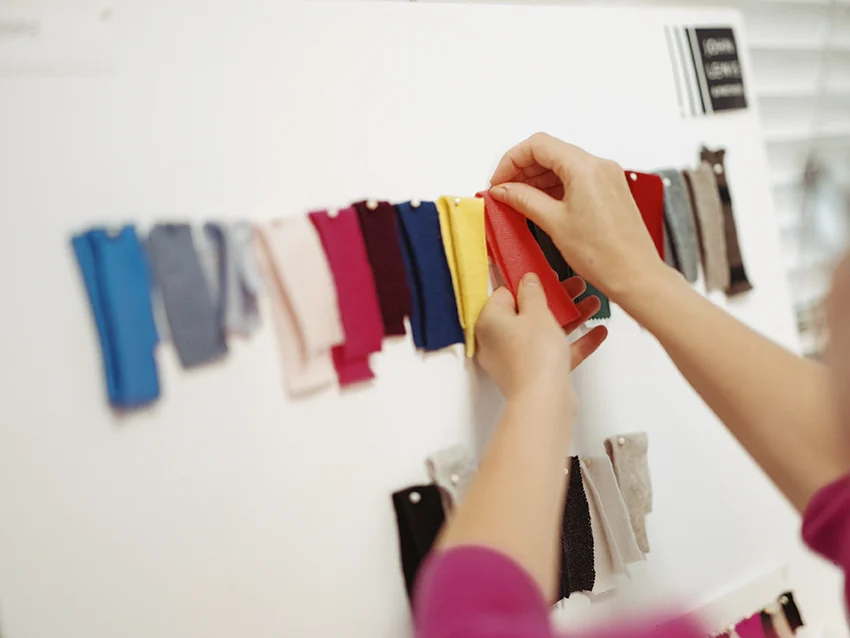 Person pinning up fabric samples