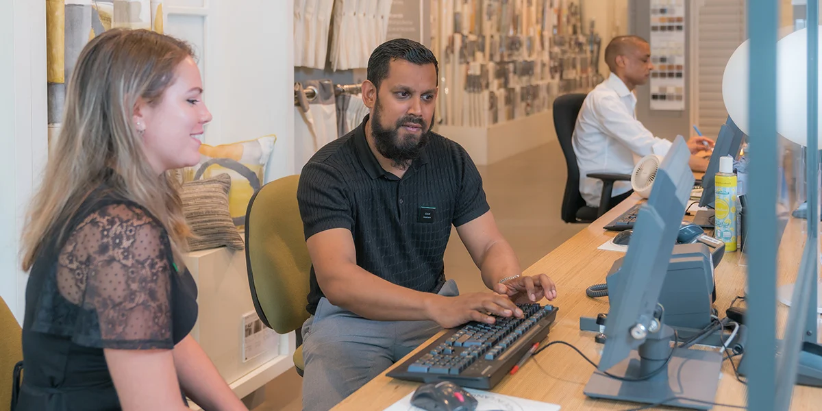 Two people in front of a computer in a retail environment