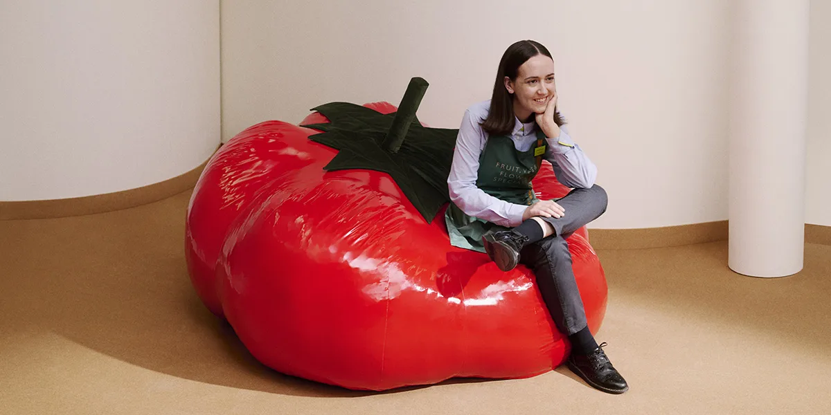Conceptual image of a person sitting on a giant tomato