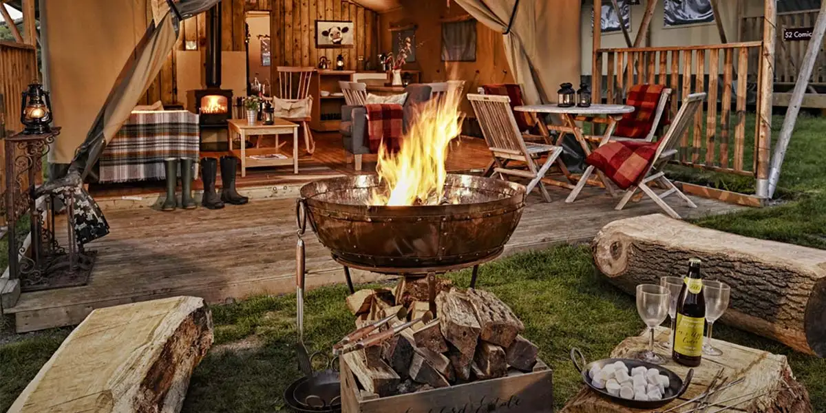 Campfire in front of a glamping tent
