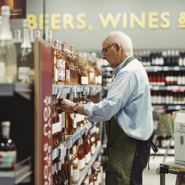 Older man restocking wine section