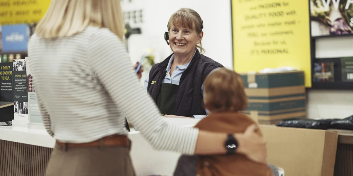 Customer Service Partner smiling at a customer and their toddler