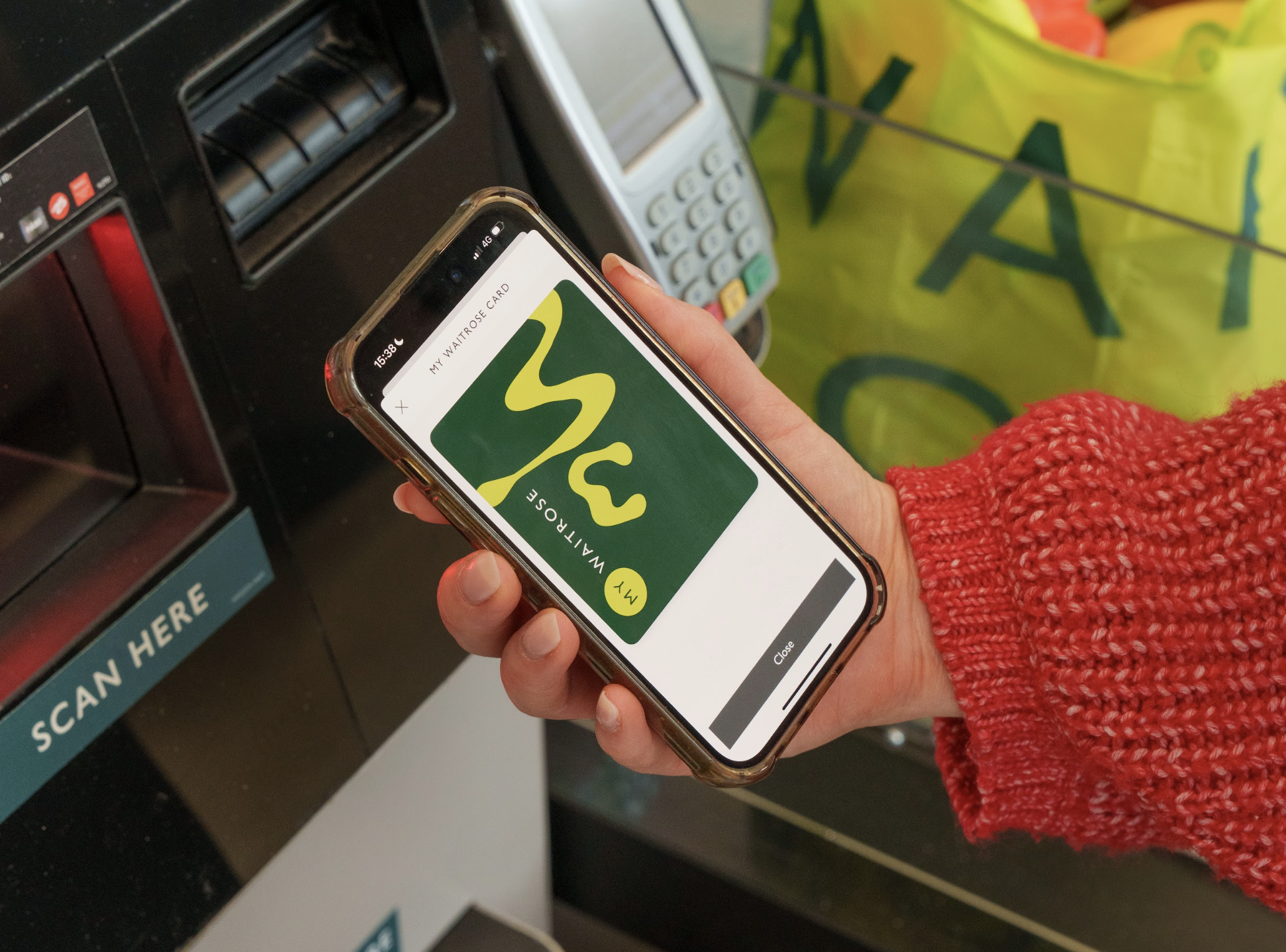 Customer holding their My Waitrose loyalty card